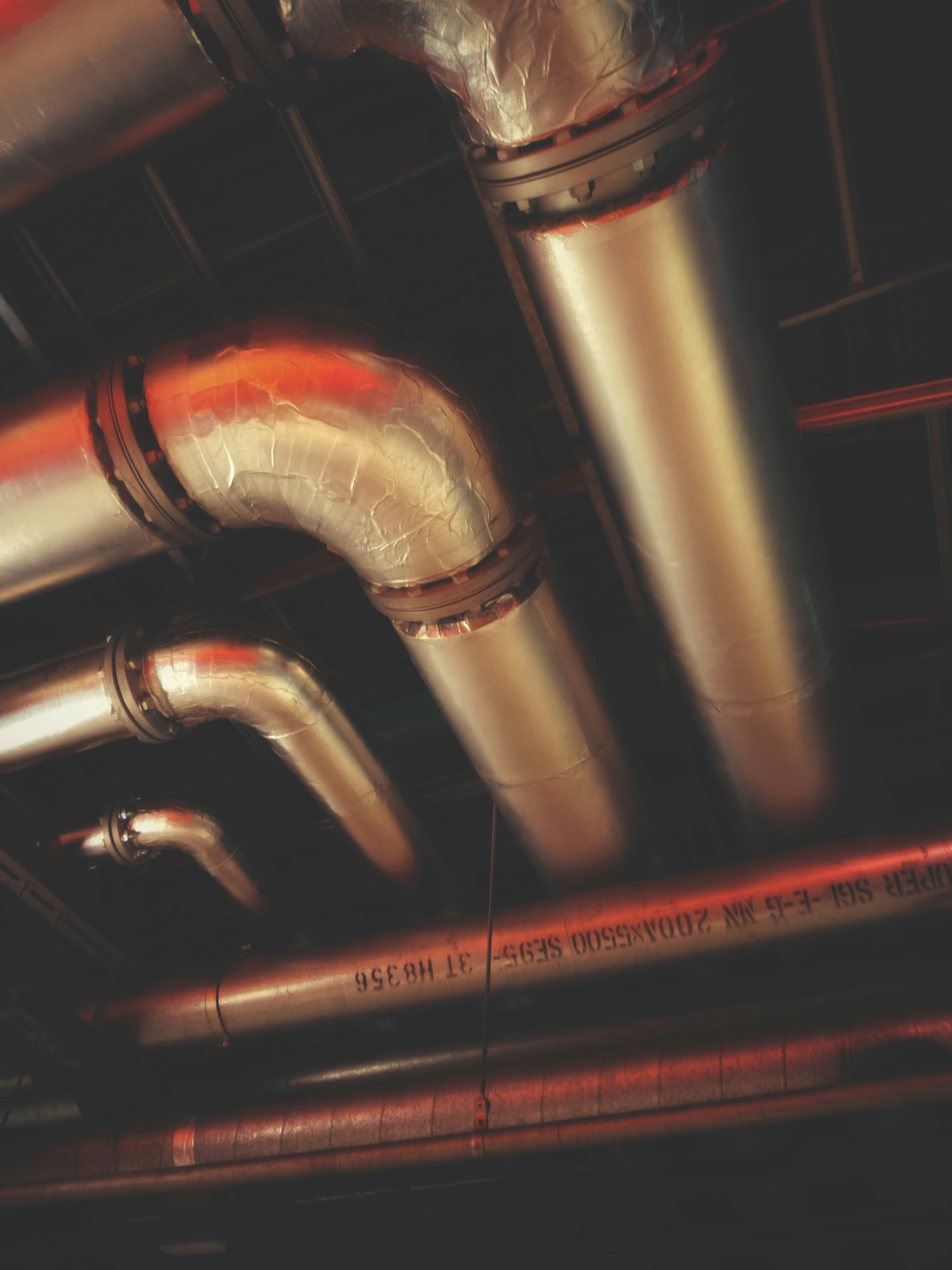 Insulated commercial pipe runs along a ceiling
